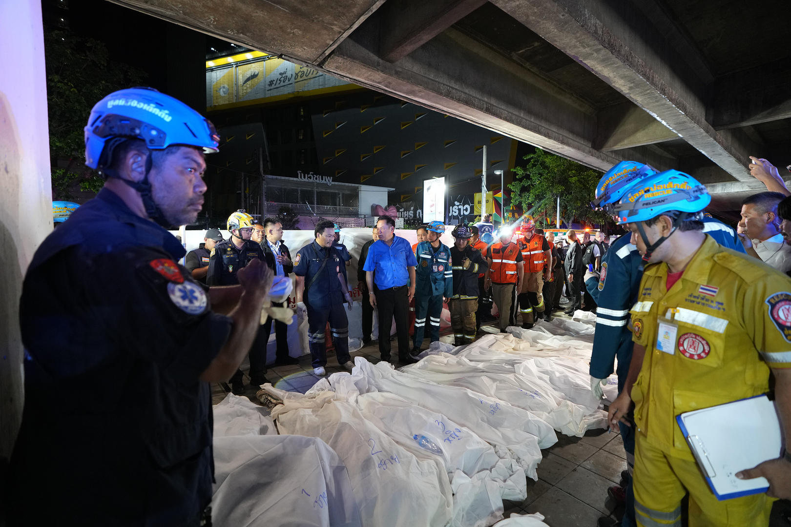 ▲当地时间2026年7月13日，泰国总理阿努廷&middot;参威拉恭（身着蓝色服装）视察火灾现场，遇难者遗体被整齐排列（图据视觉中国）