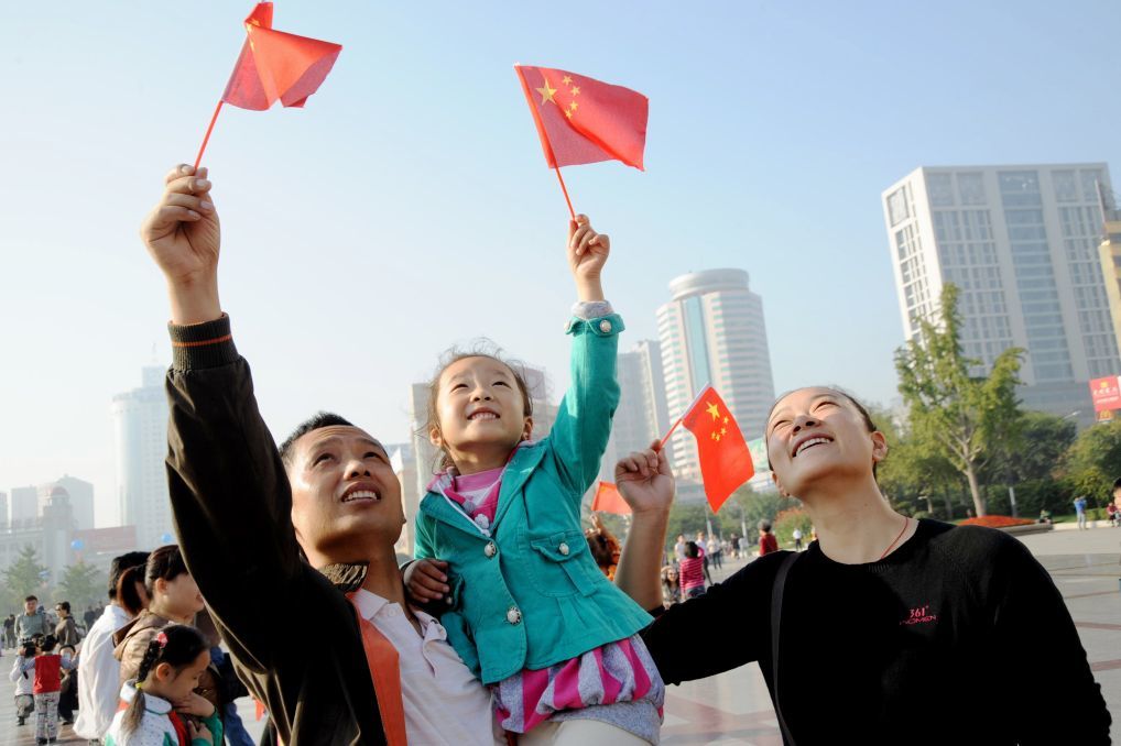 2009年10月1日,家长带着孩子来到徐州彭城广场观看升旗仪式。新华社发