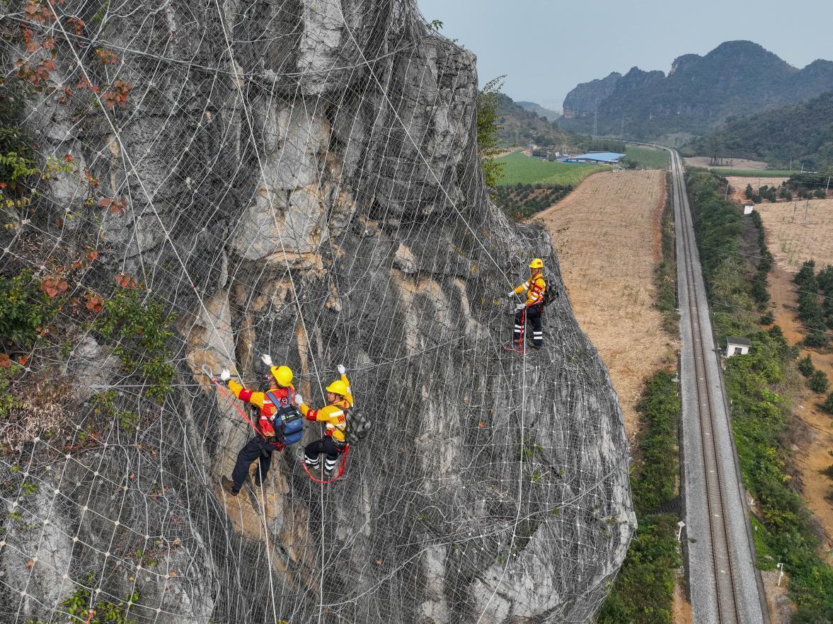 杨发登和队员借助安全绳下降至危石处