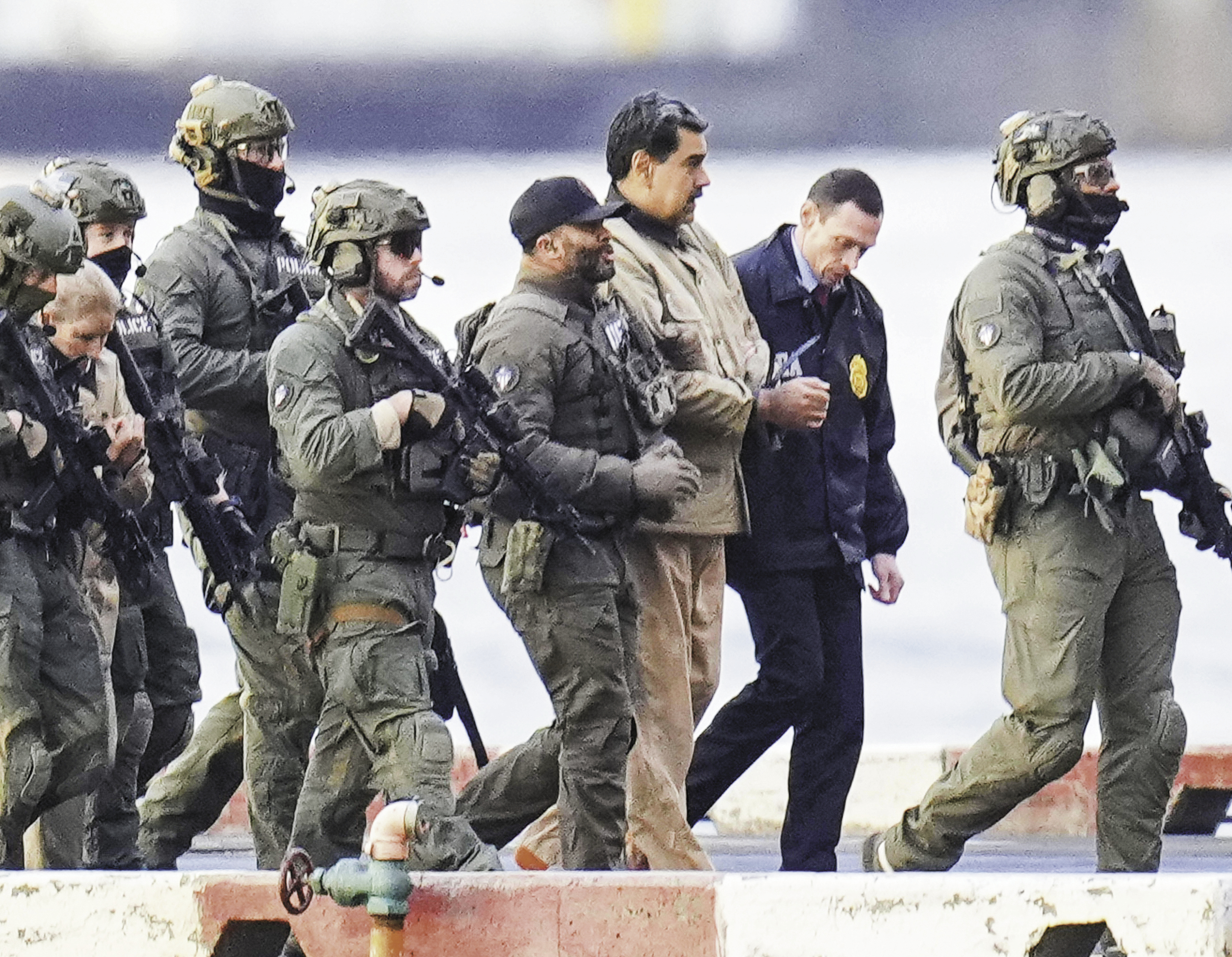 5日,委内瑞拉总统马杜罗(右三)在美国军警的押送下前往纽约南区联邦地区法院。(视觉中国)