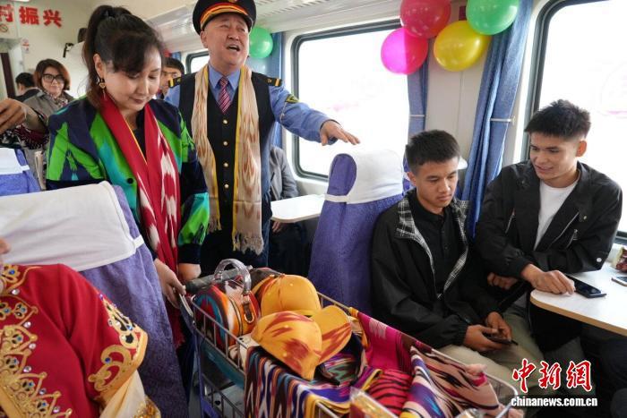 市民在慢火车上推荐和田特色产品。努尔古再丽 摄