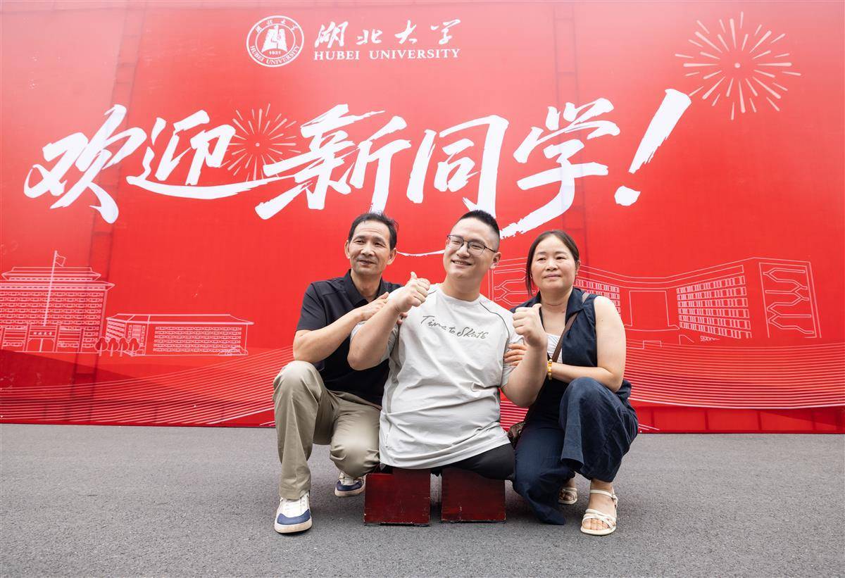 9月4日,感动全网的 “板凳男孩” 方宇翔来到湖北大学报到。图为方宇翔与父母在湖北大学合影留念。