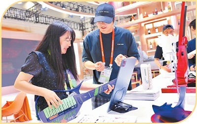 参展人员在消博会免税与高端精品展区体验赛博吉他。