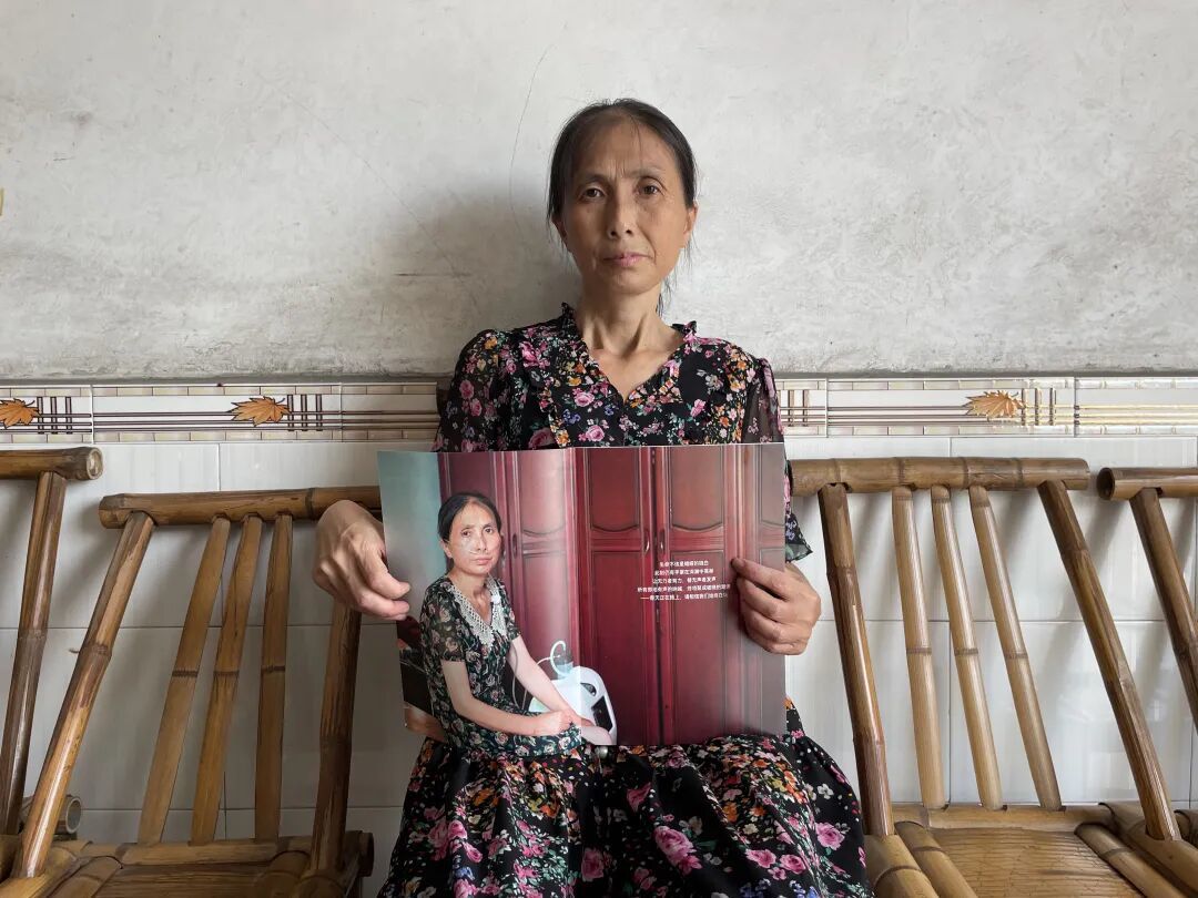 杨洁手里拿着“大爱清尘”2024年年度报告上的吸氧照片。