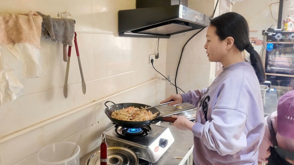↑阮氏翠姮在炒制酸笋。(刘樱涵 摄)