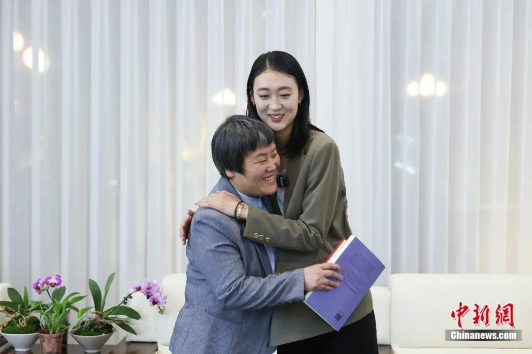 全国人大代表、河南省内黄县马上乡李石村“微光书苑”发起人李翠利接受 中新社记者专访。 图为 中新社记者采访后拥抱李翠利。 中新社记者 杨郁然 摄