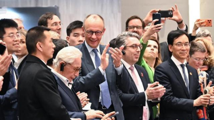 2月26日,德国总理默茨为表演中国武术的人形机器人鼓掌。