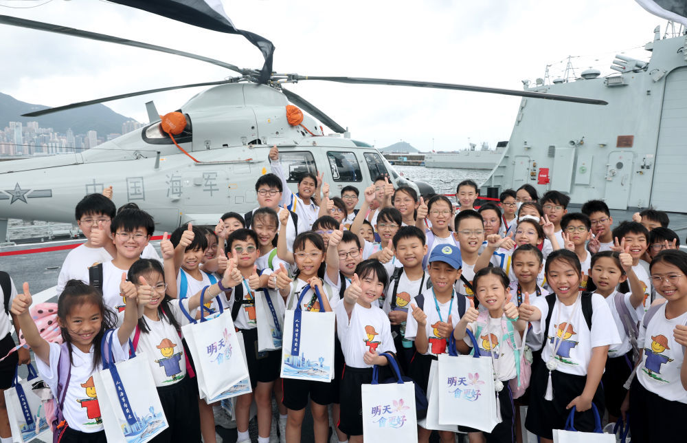 7月3日,在驻香港部队昂船洲军营码头,青少年学生在中国海军南宁舰上参观留影。新华社发(易定摄)