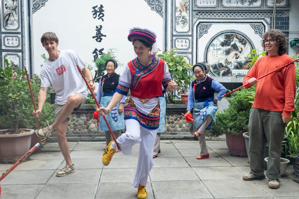 8月4日,美国青年在云南大理洱源县学习白族霸王鞭。新华社发(罗新才 摄)
