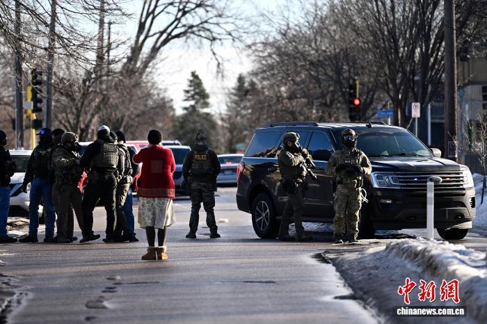 当地时间2026年1月13日，美国明尼苏达州明尼阿波利斯，一名女子看着移民海关执法局(ICE)人员封锁一个十字路口。图/视觉中国