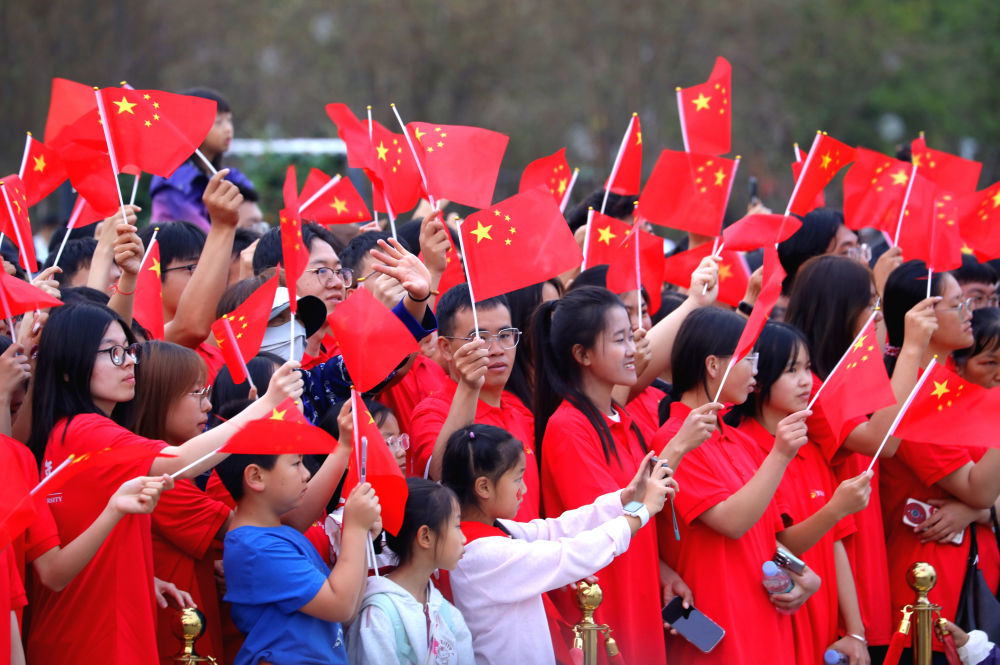 10月1日，人们在云南省昆明市东风广场参加升旗仪式后观看演出。 新华社发（郑益 摄）