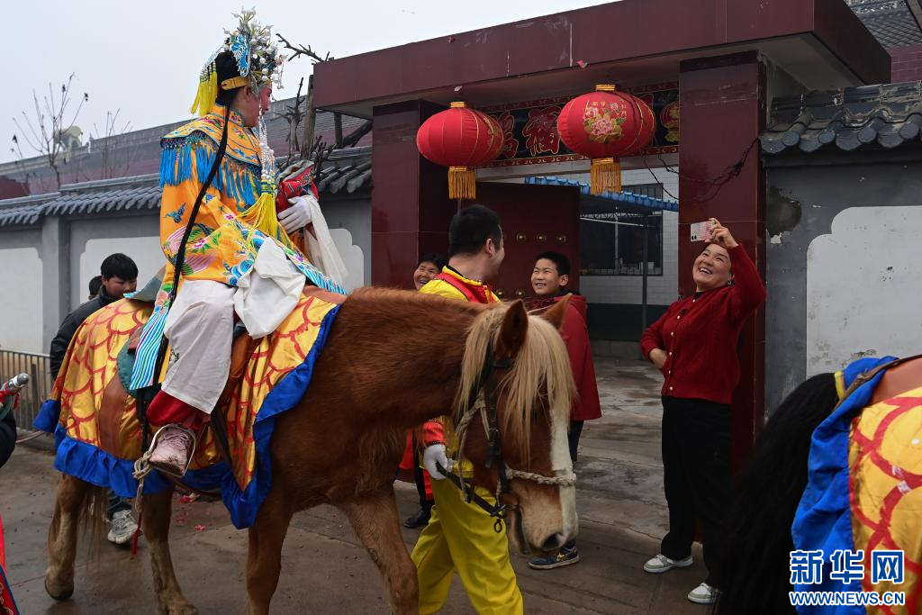 3月2日,陇县黄花峪村村民在家门口迎接社火队。新华社记者 邹竞一 摄