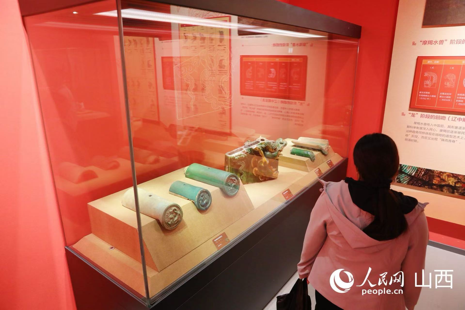 游客正在了解古代建筑琉璃构件。人民网记者 王帆摄
