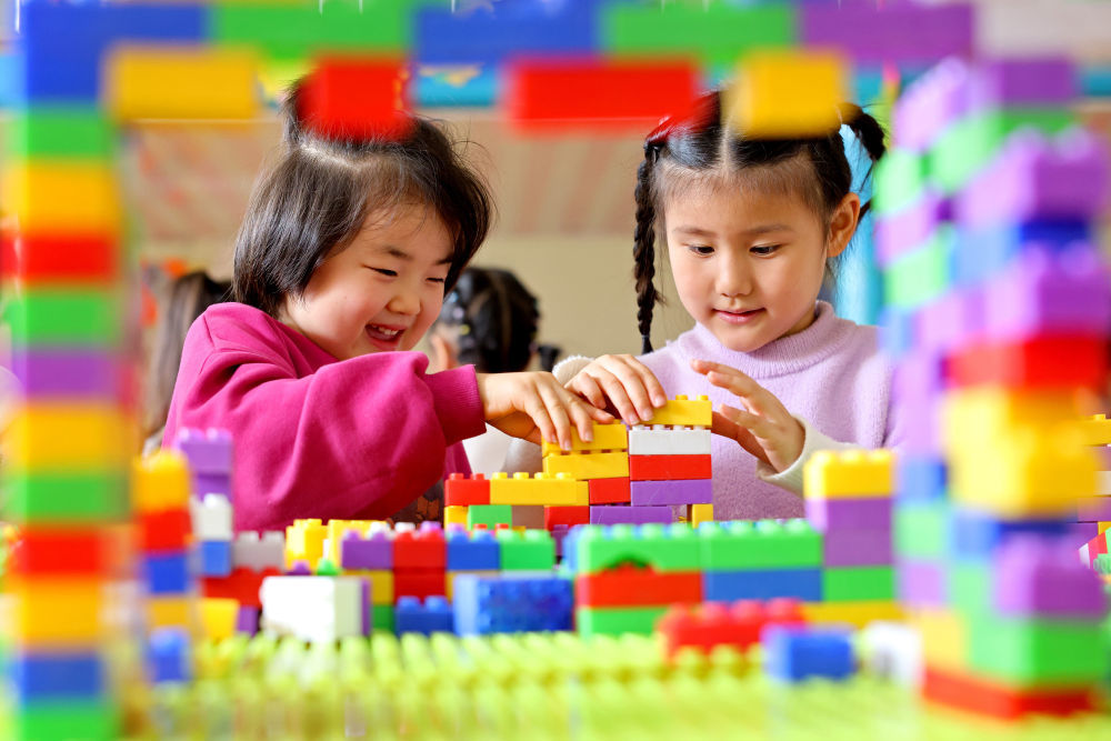 2025年11月6日,在山东省枣庄市市中区西王庄镇中心幼儿园,托育班的小朋友在拼搭积木。新华社发(孙中喆 摄)