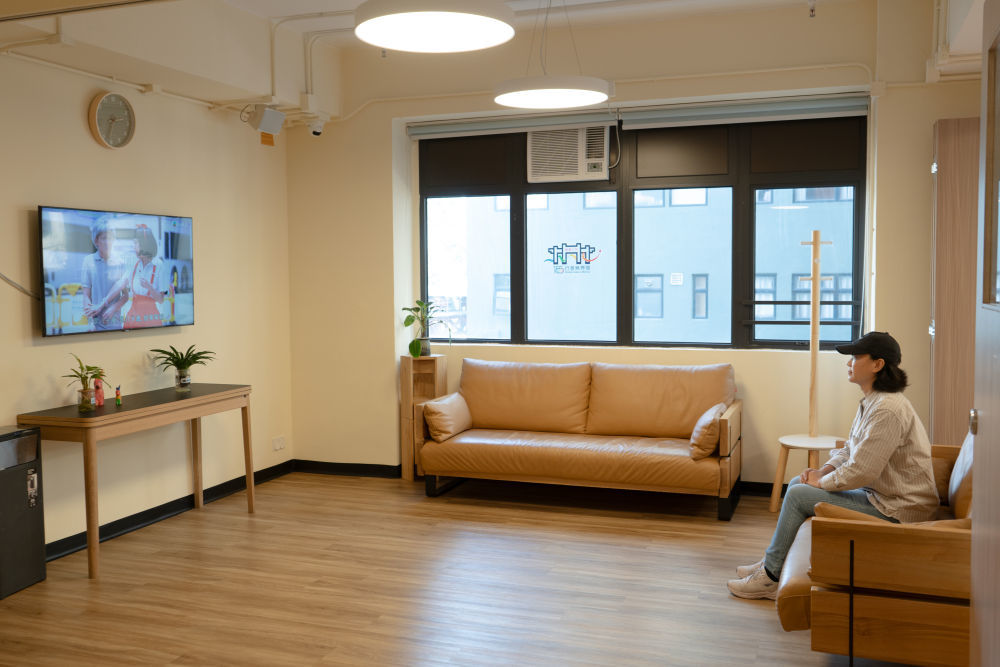 2025年11月26日,夏女士在土瓜湾“社区客厅”看电视。新华社发(谭佳铭 摄)