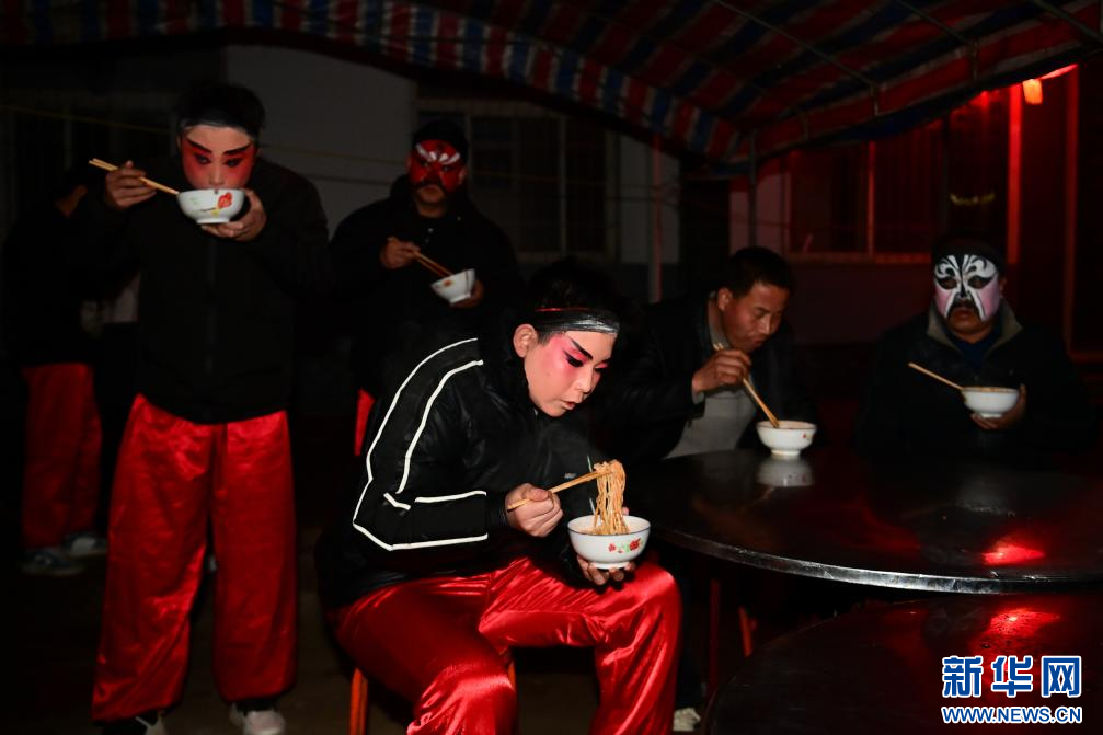 3月2日凌晨,陇县黄花峪村社火队队员在吃早饭。新华社记者 邹竞一 摄