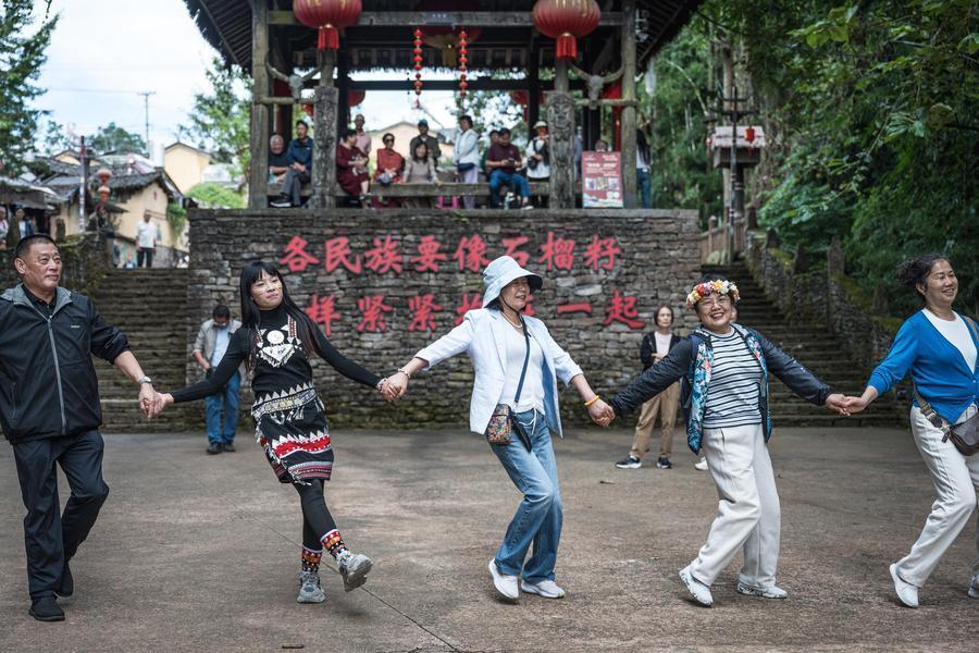 10月19日,在腾冲市清水镇三家村中寨司莫拉佤族村,游客和演职人员一起打跳。