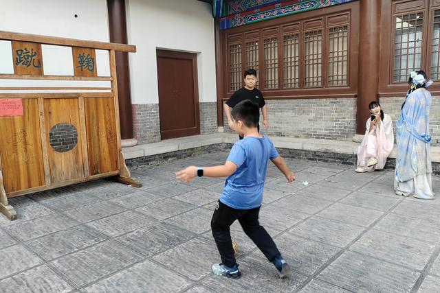 10月3日,阳谷县狮子楼景区,小朋友在体验蹴鞠。 夏旭光 摄