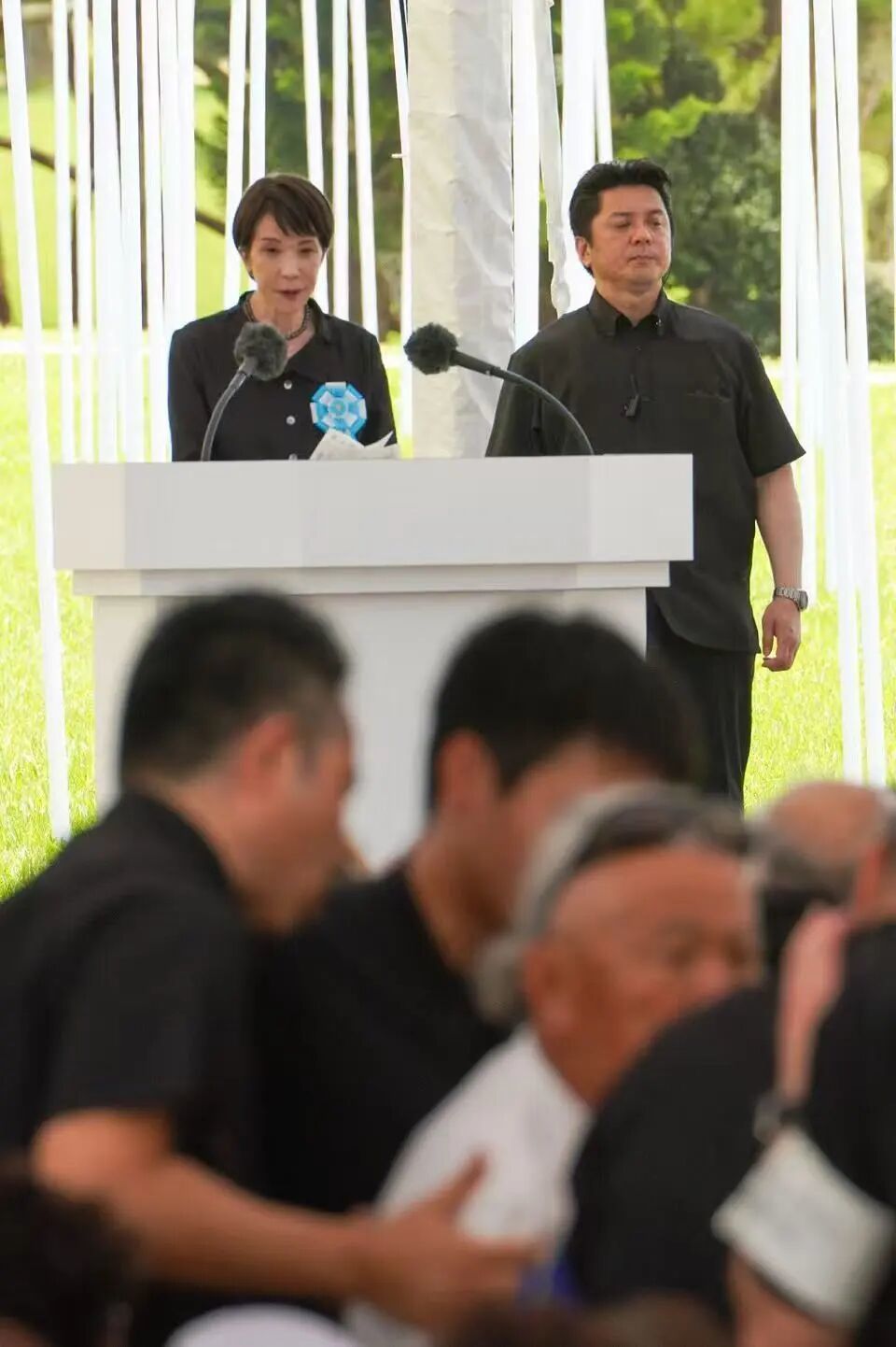 6月23日，在高市早苗演讲时，一名抗议者被带离现场。图自《冲绳时报》