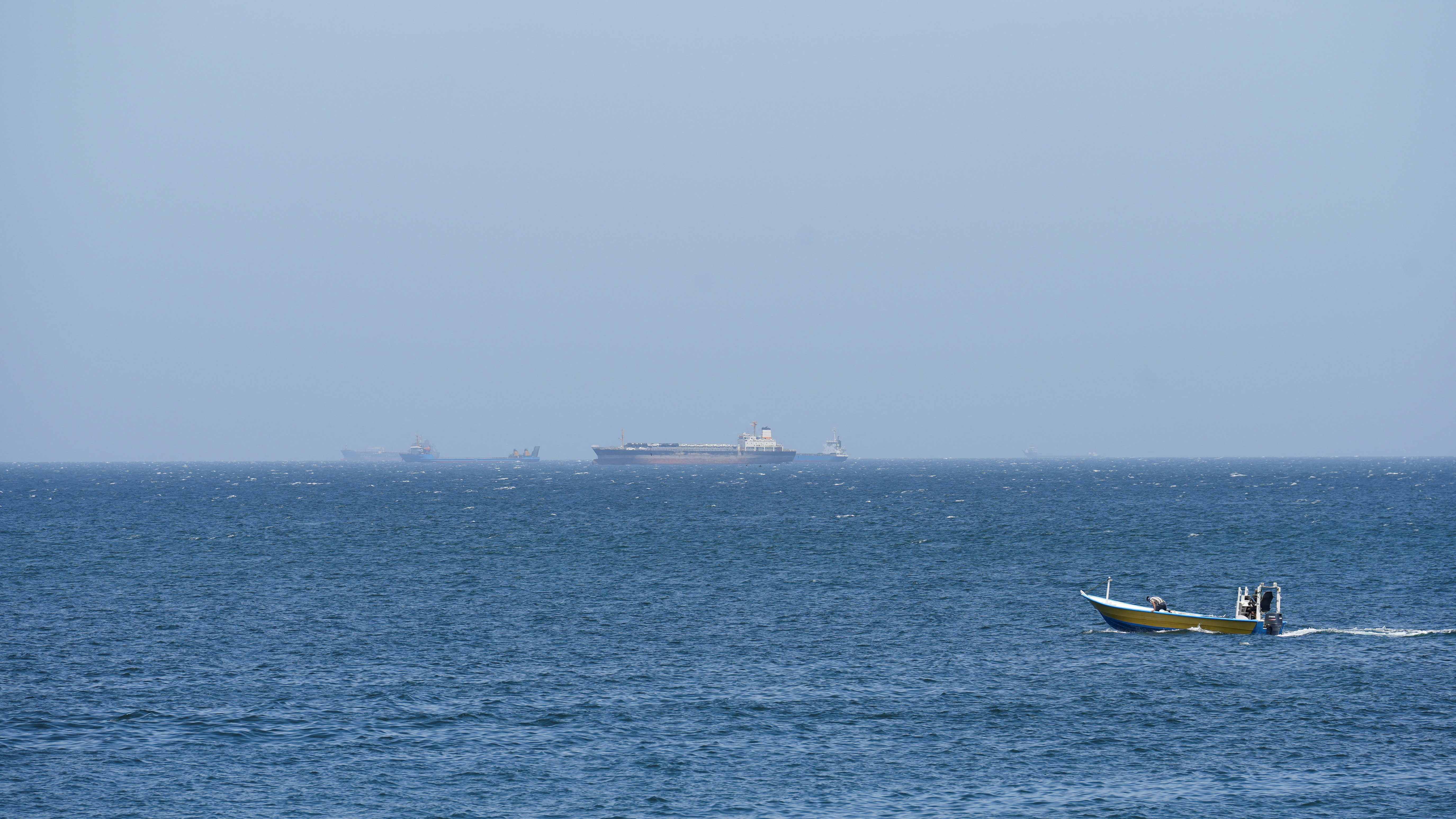 当地时间2026年4月8日,从阿曼穆桑代姆省眺望霍尔木兹海峡,船只停泊在海岸附近。 IC photo