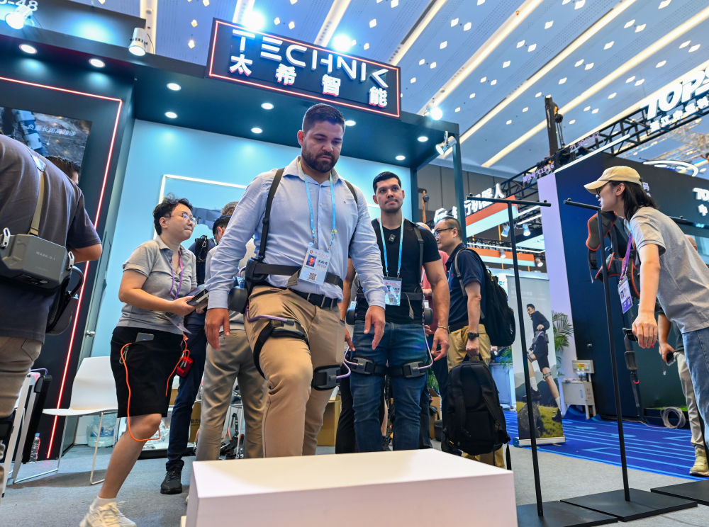 2025年10月15日，境外采购商在第138届广交会服务机器人专区太希智能展台体验登山助行外骨骼穿戴设备。