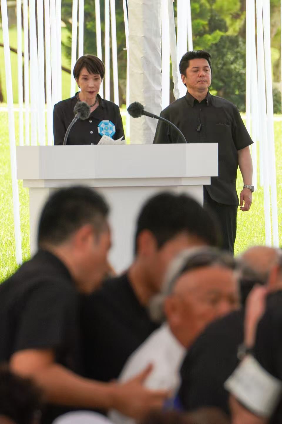 6月23日，在高市早苗演讲时，一名抗议者被带离现场。图自《冲绳时报》