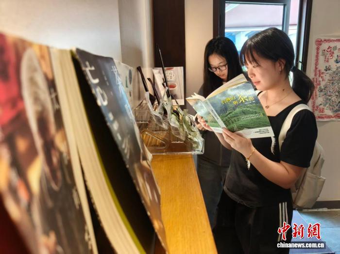 7月24日，武汉年轻茶客在“小茶原”茶馆取阅介绍台湾知识的书籍。　胡冕 摄