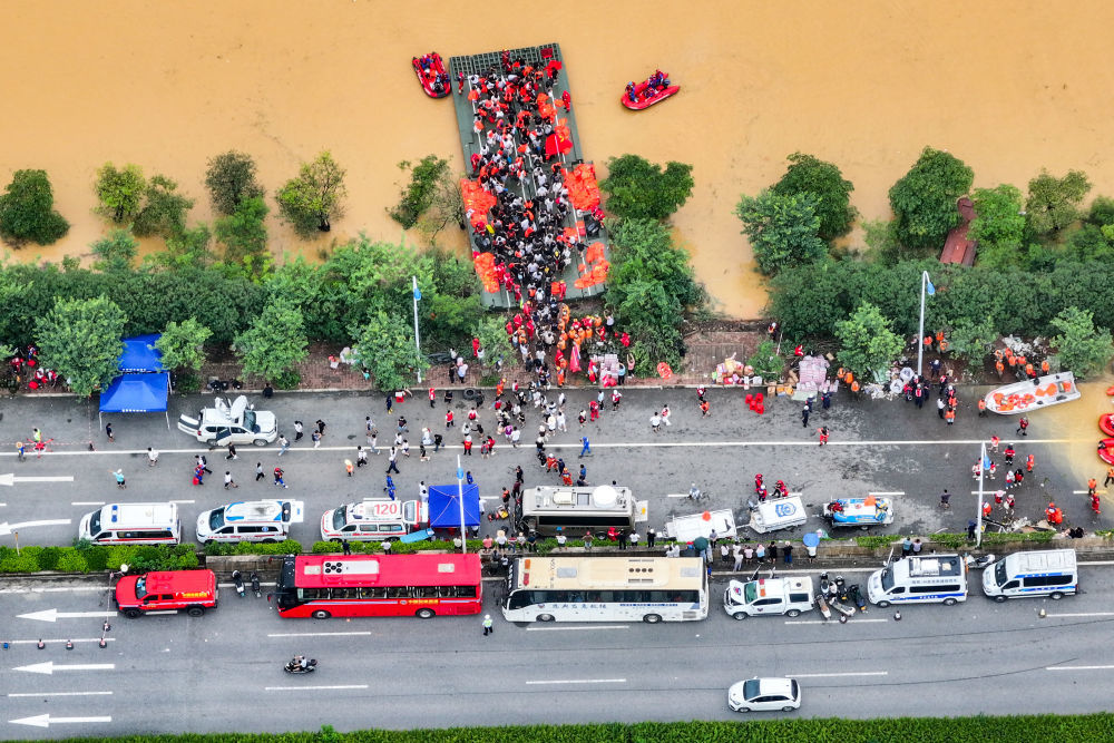↑ 7月9日,在广西贵港市西江教育园区,被困学生有序上岸(无人机照片)。新华社记者 周华 摄