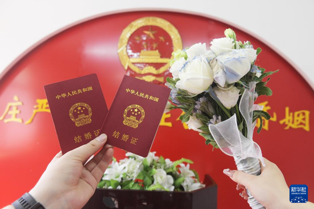 一对新人在婚姻登记处领取结婚证后拍照留念。 新华社