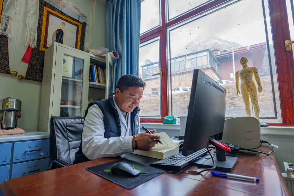 2月5日，玉麦乡卫生院副院长次旦米久在办公室研读藏医书籍。新华社记者 丁增尼达 摄