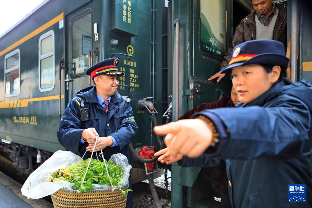 2月25日,在遵义市,5630次列车到达桐梓站后,铁路工作人员协助村民搬运蔬菜下车。新华社发(张贵忠 摄)