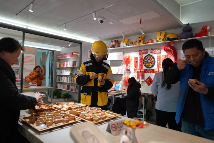 2月4日，快递小哥在北京什刹海二十四小时“友好驿站”中品尝免费的蛋糕。新华每日电讯记者谢晗 摄