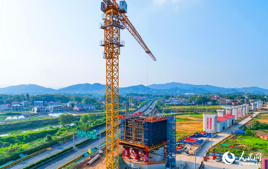 萍乡市上栗县金山镇的栗水河特大桥建设现场,塔吊林立,工业作业繁忙,基桩浇筑有序推进。人民网记者 朱海鹏摄