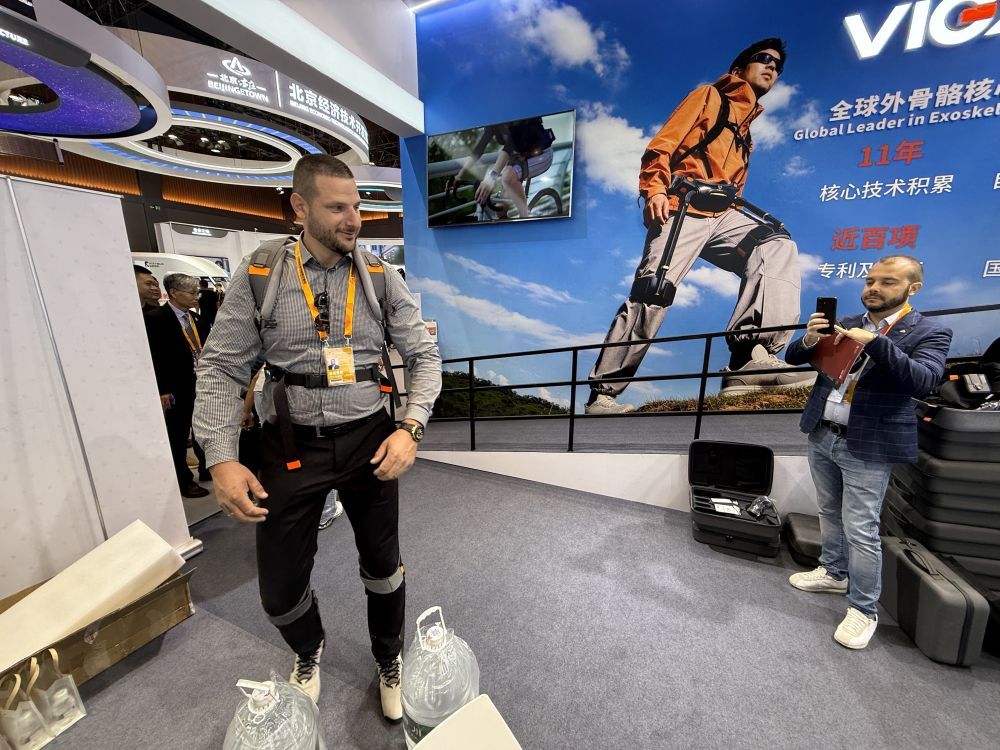 一位外籍参展嘉宾兴奋地体验外骨骼机器人。新华社记者 张骁 摄