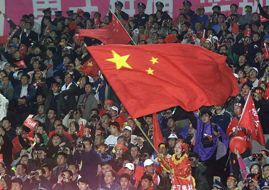 2001年10月7日，沈阳五里河体育场，中国队对阵阿曼队的比赛中，球迷们在看台上挥舞国旗。