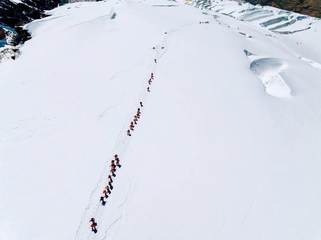 2024年7月11日，慕士塔格峰上长长的登山队伍。图/视觉中国