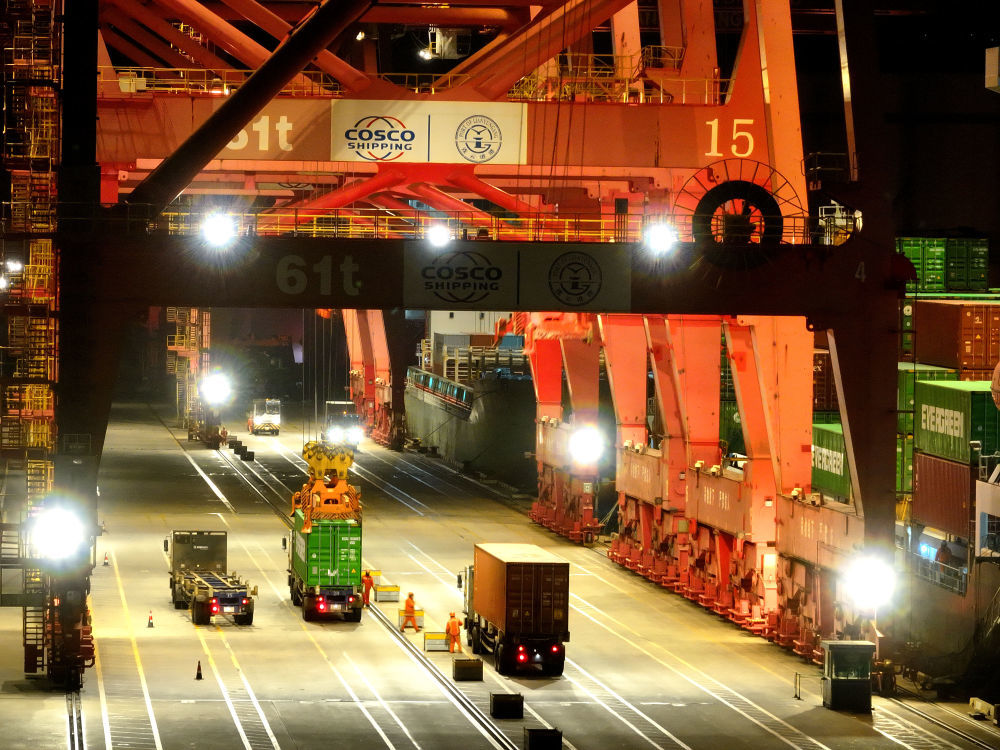 ↑ 2月16日凌晨，江苏省连云港港集装箱码头灯火通明，工作人员在运输、装卸集装箱（无人机照片）。新华社发（王春摄）