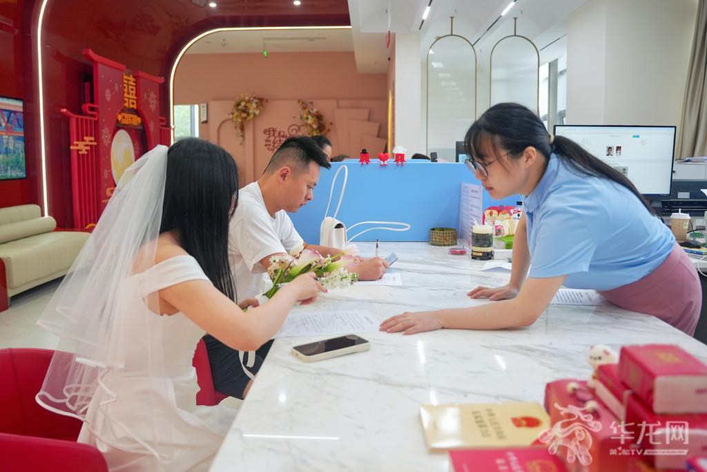 前来登记的新人在工作人员的帮助下进行婚姻登记。第1眼TV-华龙网记者 辛飞 摄