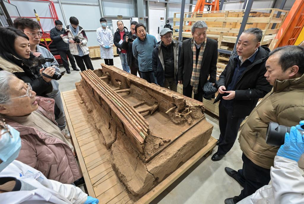 巴达木东晋唐时期墓群考古发掘负责人尚玉平（右二）向专家们介绍墓葬M20出土的彩绘木棺座。新华社记者 李贺 摄