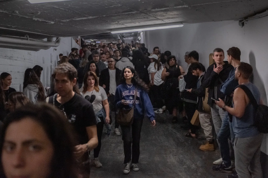 特拉维夫一处地下防空避难所内的人群。周五空袭警报期间,人们进入特拉维夫地下防空避难所。