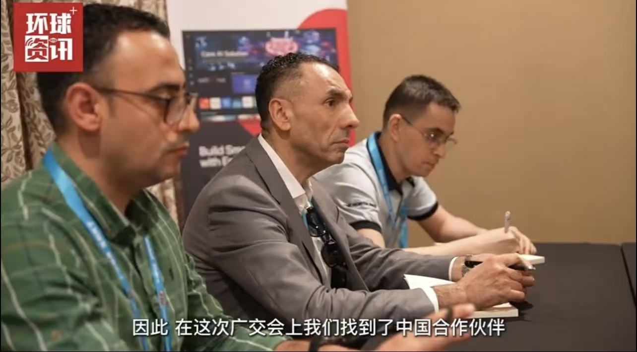 阿尔及利亚采购商阿里（中）正和同事一起与中国企业洽谈