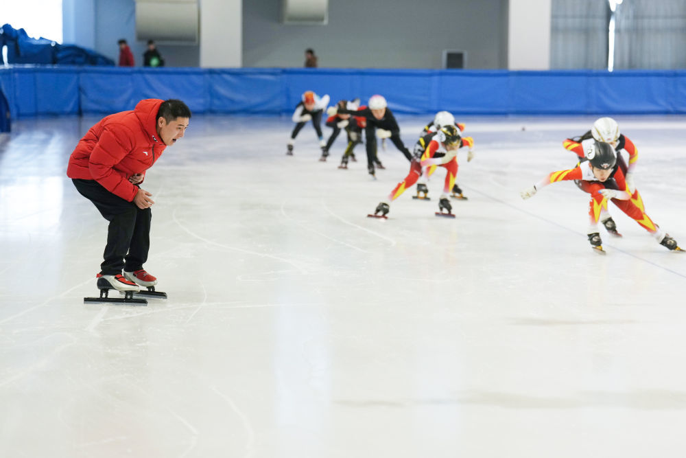 2025年1月24日，短道速滑教练姚忠华（左）在黑龙江省七台河市短道速滑馆指导运动员进行冰上训练。十余年来，姚忠华累计执教培养过200余名运动员。七台河市拥有“奥运冠军之城”的城市名片，在这里，教练员们一起筑梦冰场，为我国冰雪人才的储备奉献自己的力量。