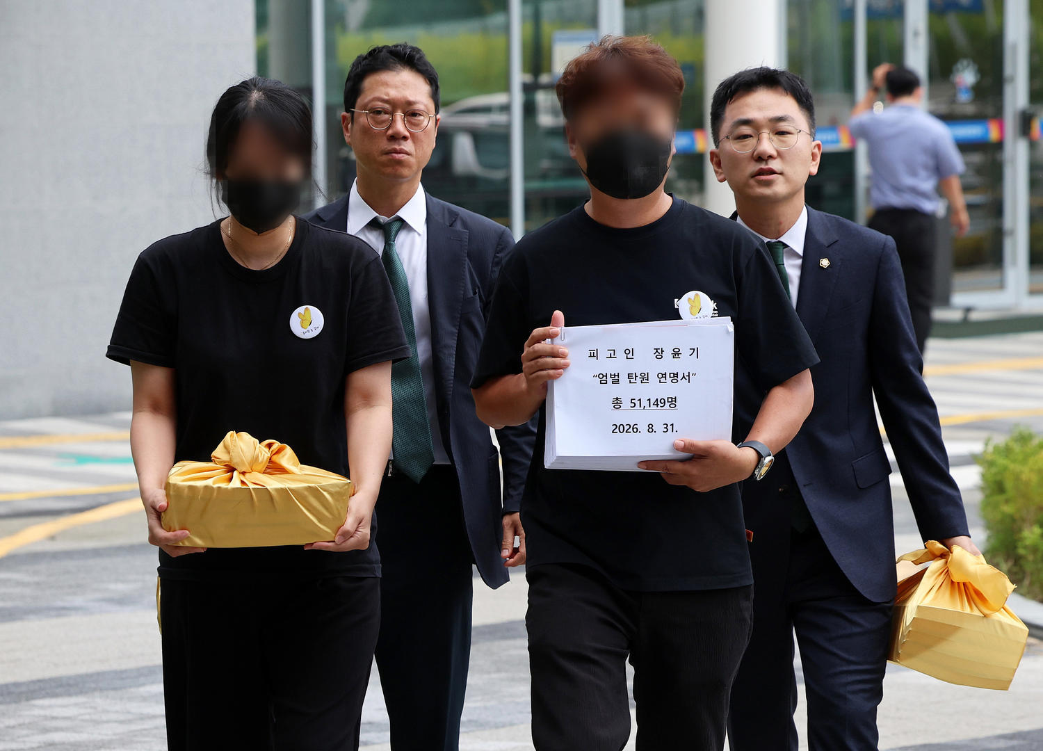 ▲当地时间2026年8月31日,韩国光州,“女高中生杀害案”凶手张允基一审第四次公审当天,遇害者李采元的父母与律师手持严惩请愿书前往光州地方法院信访室(图据视觉中国)