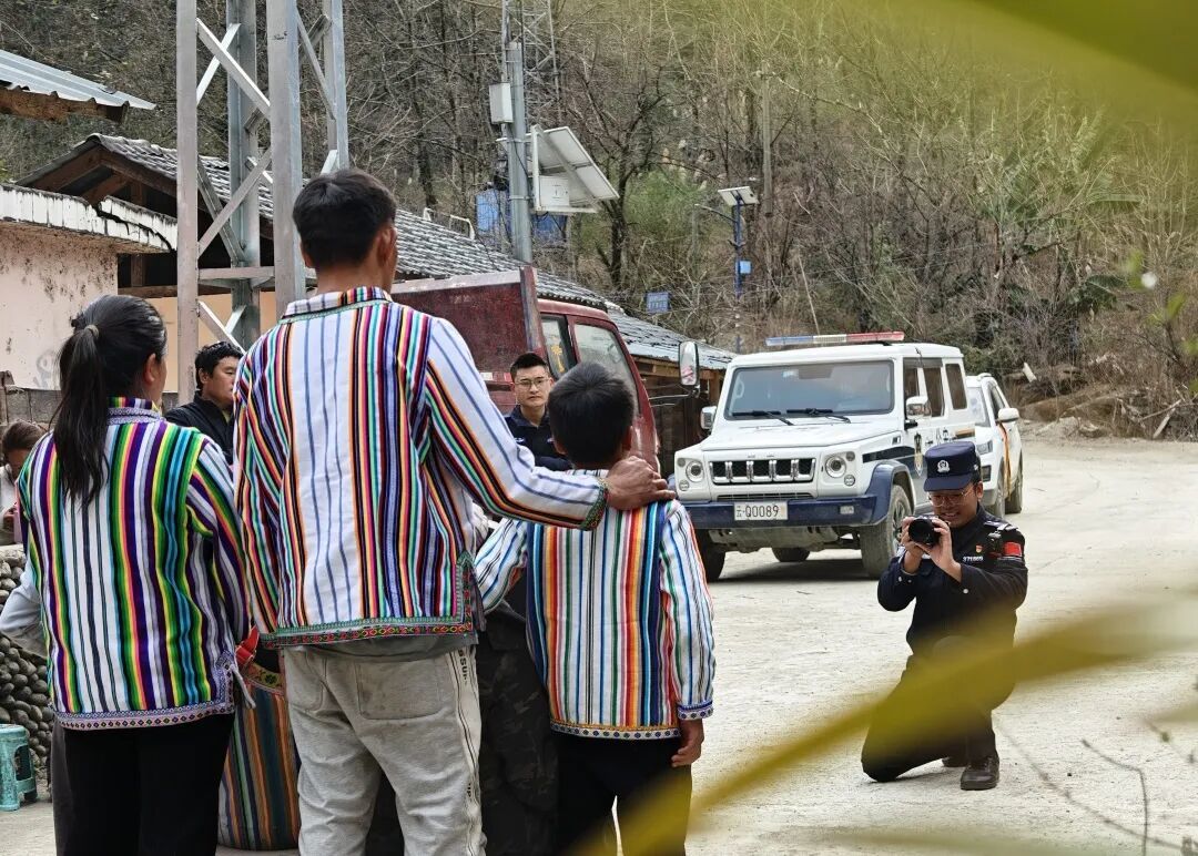 民警余润强正在为乡亲们拍摄全家福。