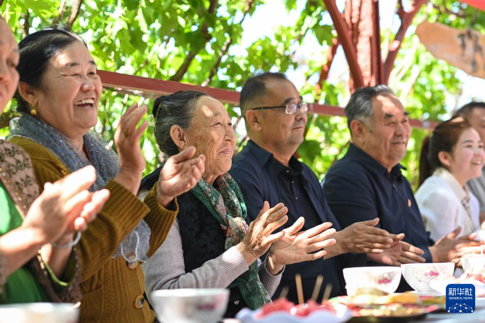 干部群众在新疆伊宁县喀拉亚尕奇乡喀拉亚尕奇村“伊犁人的奶茶会”观看表演（5月14日摄）。