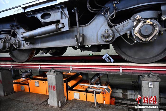 3月25日,位于福建省福州市的福州南动车所内,智能检测机器人正对动车组底部零部件进行全方位扫描。智能检测机器人34分钟即可完成一列动车组车底扫描,整体作业效率提升40%。中新社记者 张斌 摄