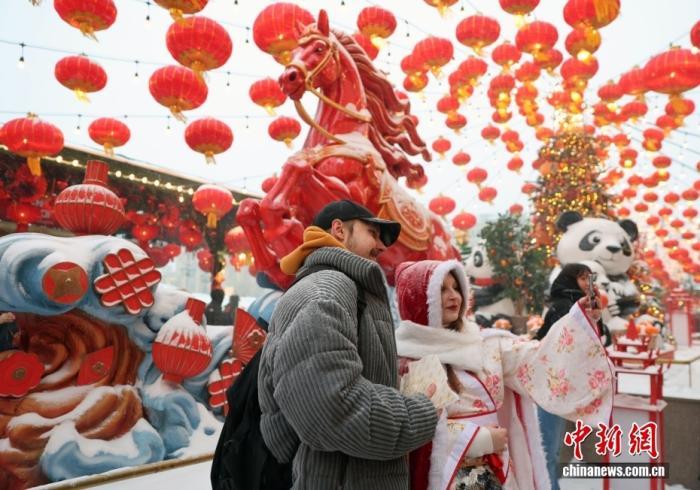 当地时间2月16日,中国农历除夕,第三届莫斯科“欢乐春节”活动在莫斯科市中心隆重启幕。图为一对情侣以奔马雕塑为背景合影。 中新社记者 田冰 摄