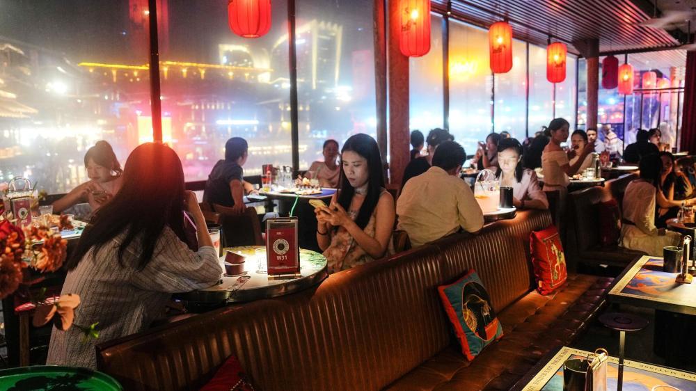 10月3日晚,夜游的南宁市民在南宁民歌湖餐吧休憩。 新华社记者 张爱林 摄