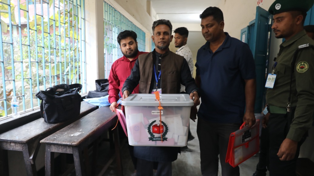 2月12日,在孟加拉国首都达卡,选举工作人员在投票站运送票箱。新华社 图