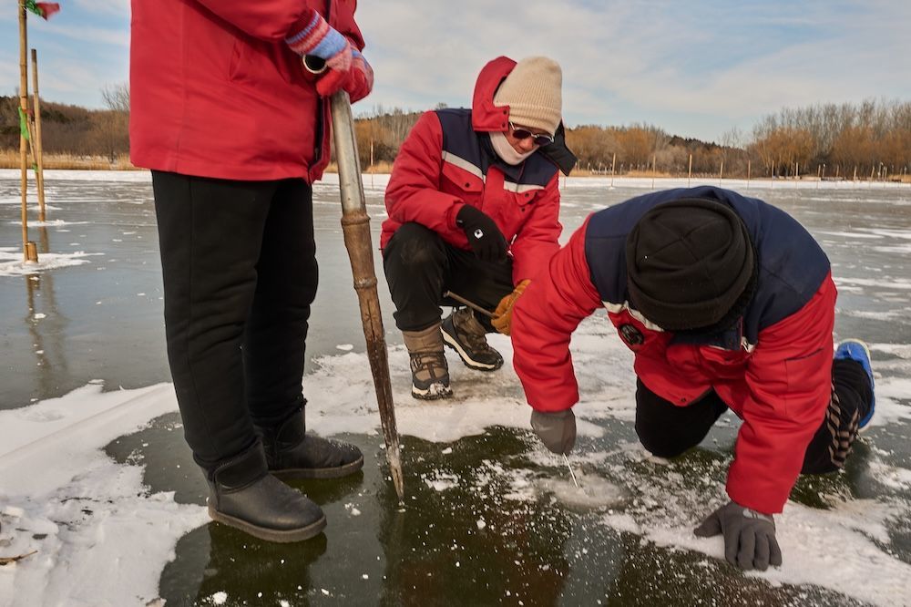 2026年1月18日，奥森公园冰场，工友们跪在地上测量冰面的厚度。